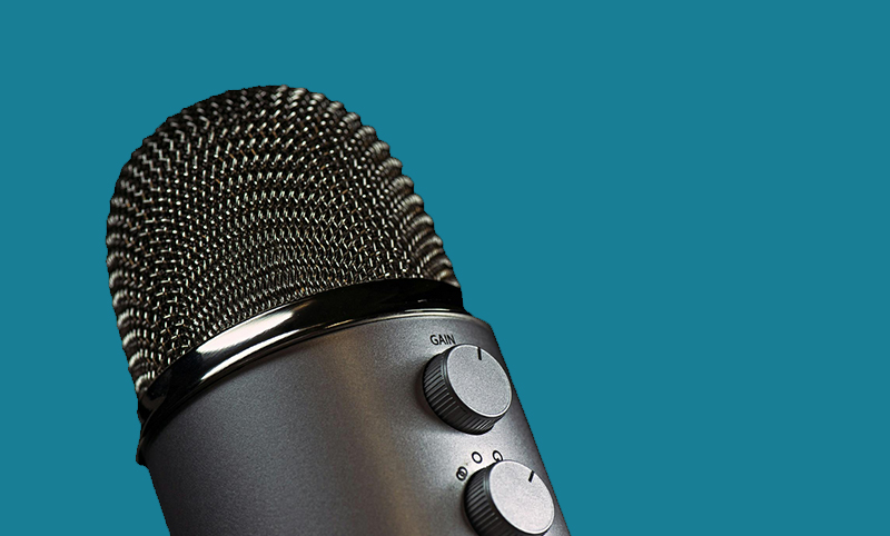 Microphone against a teal background.