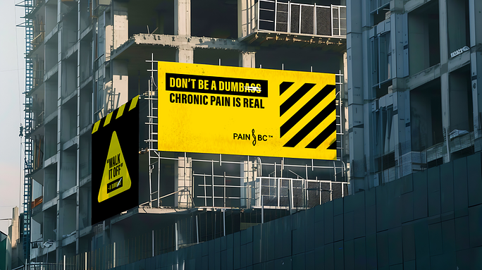 Building with a large yellow sign which says Don't be a dumb*ss chronic pain is real.