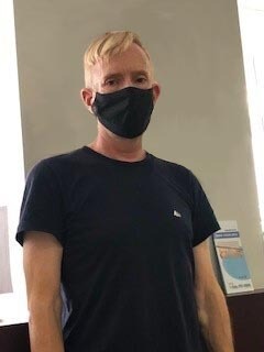 Craig wearing a mask and a black T-shirt