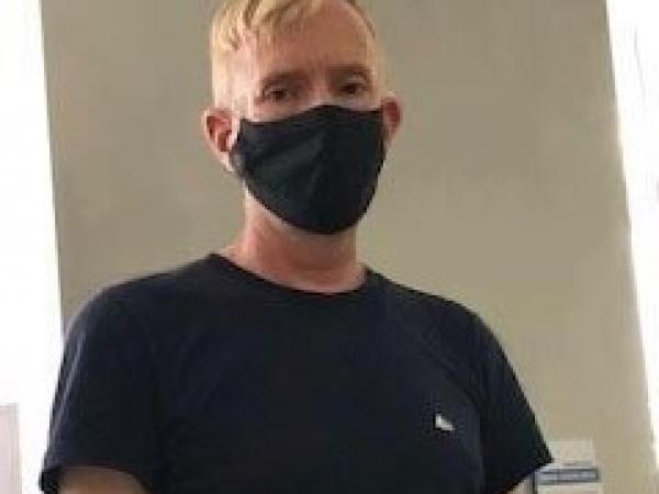 Craig wearing a mask and a black T-shirt